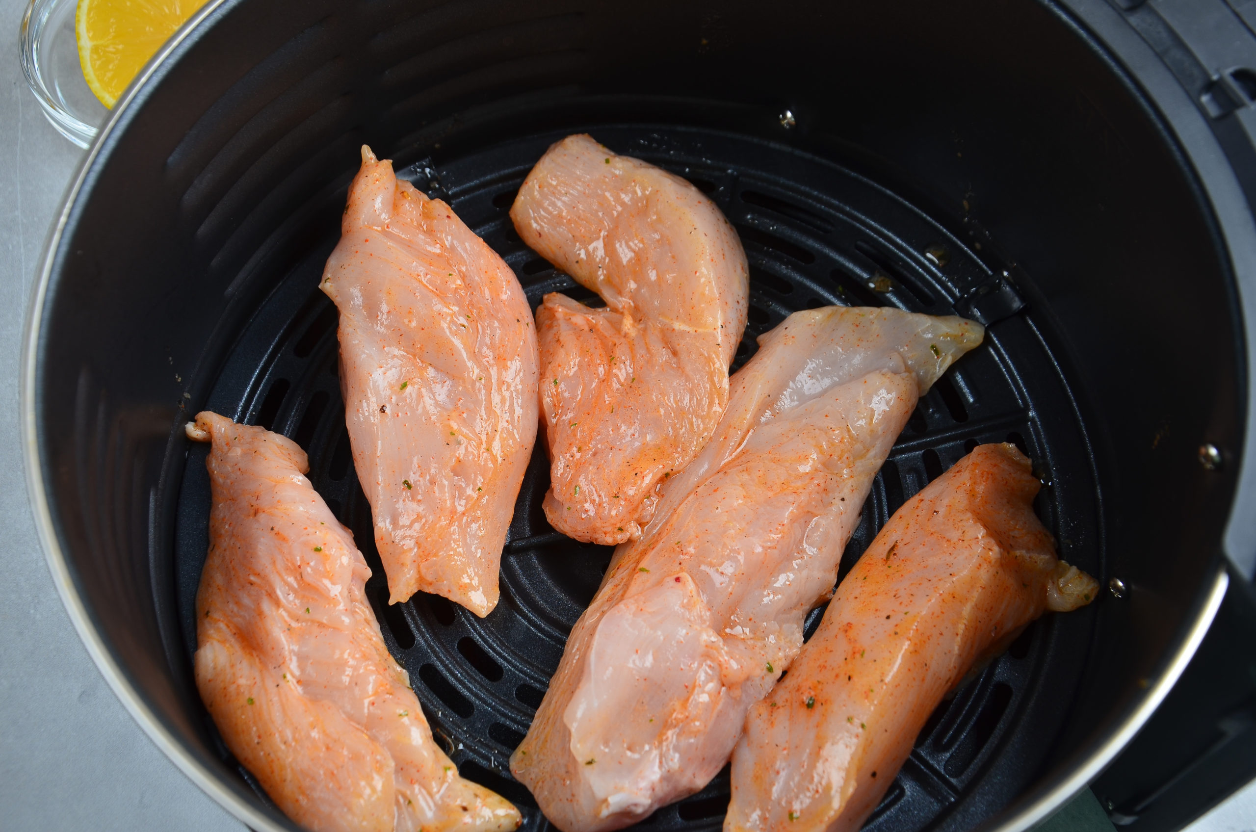 Strips of marinated chicken in an air fryer